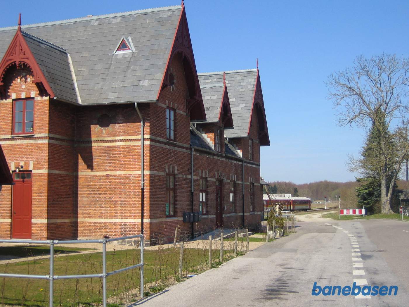 Stationen set fra vejen. Persontoget på vej til Køge