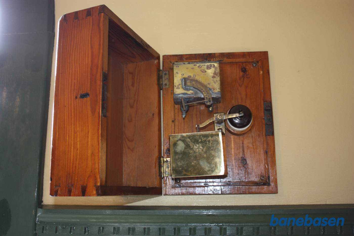 En "timer" der slukker for lyset. Vand drypper ned fra den øverste beholder ned i den nederste. Den elektriske kontakt med sort låg ses til højre for vippearmen. Låget til at åbne er den store kasse til venstre