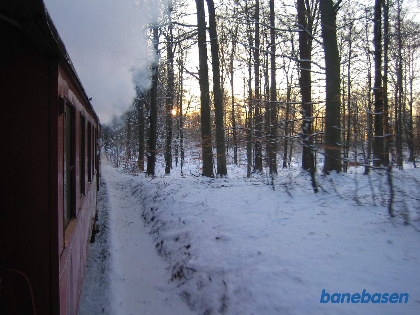 Toget på vej gennem skoven nær Sortesø, på vej ned til Mårum, hvor gæsterne står og venter med deres juletræer Toget på vej gennem skoven nær Sortesø, på vej ned til Mårum, hvor gæsterne står og venter med deres juletræer