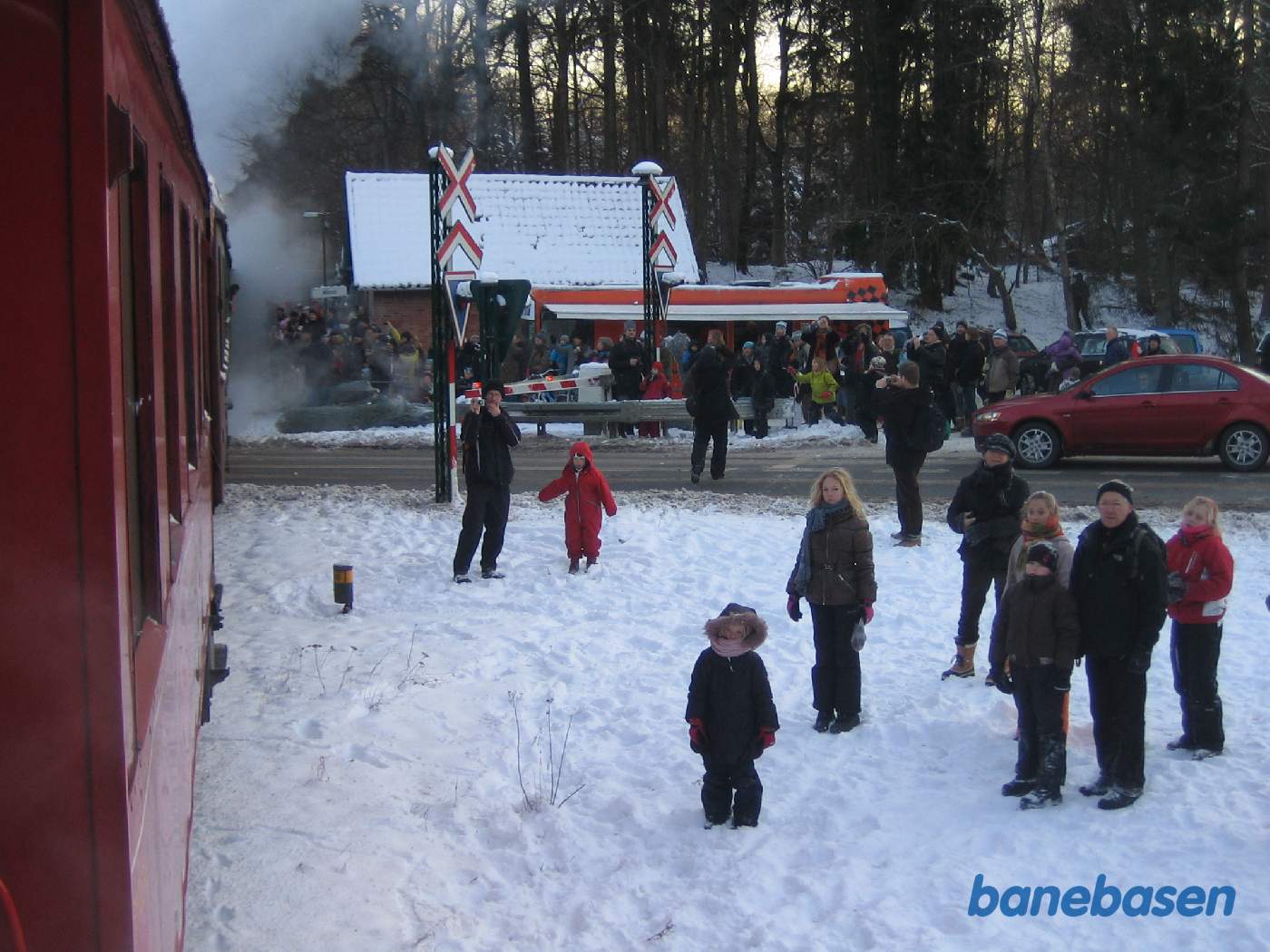 Toget på vej over overkørslen i Mårum, hvor gæsterne står og venter med deres juletræer