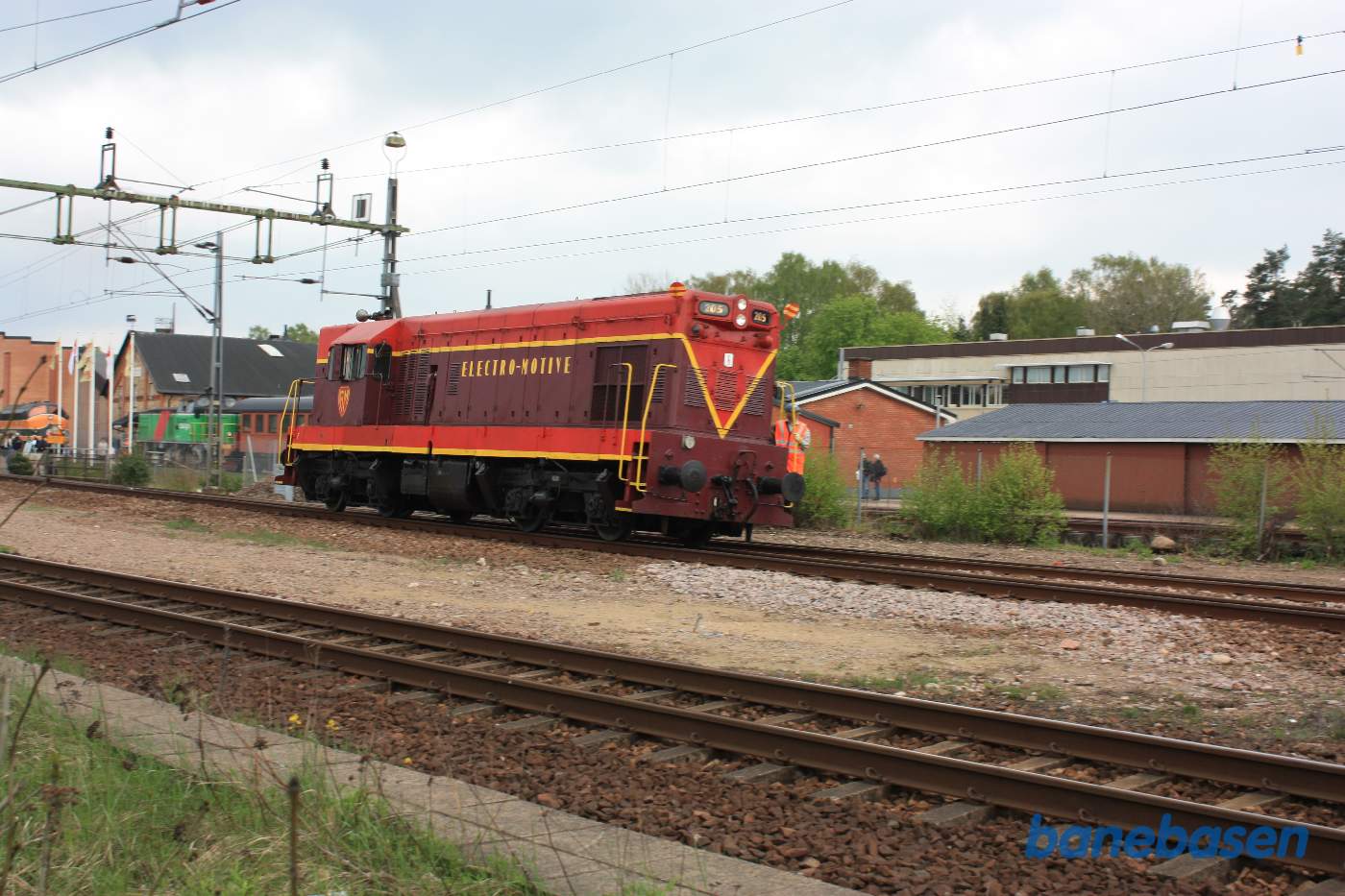 Et rødt Electro-Motive lokomotiv har forladt museets område og kørt ud på stationsområdet