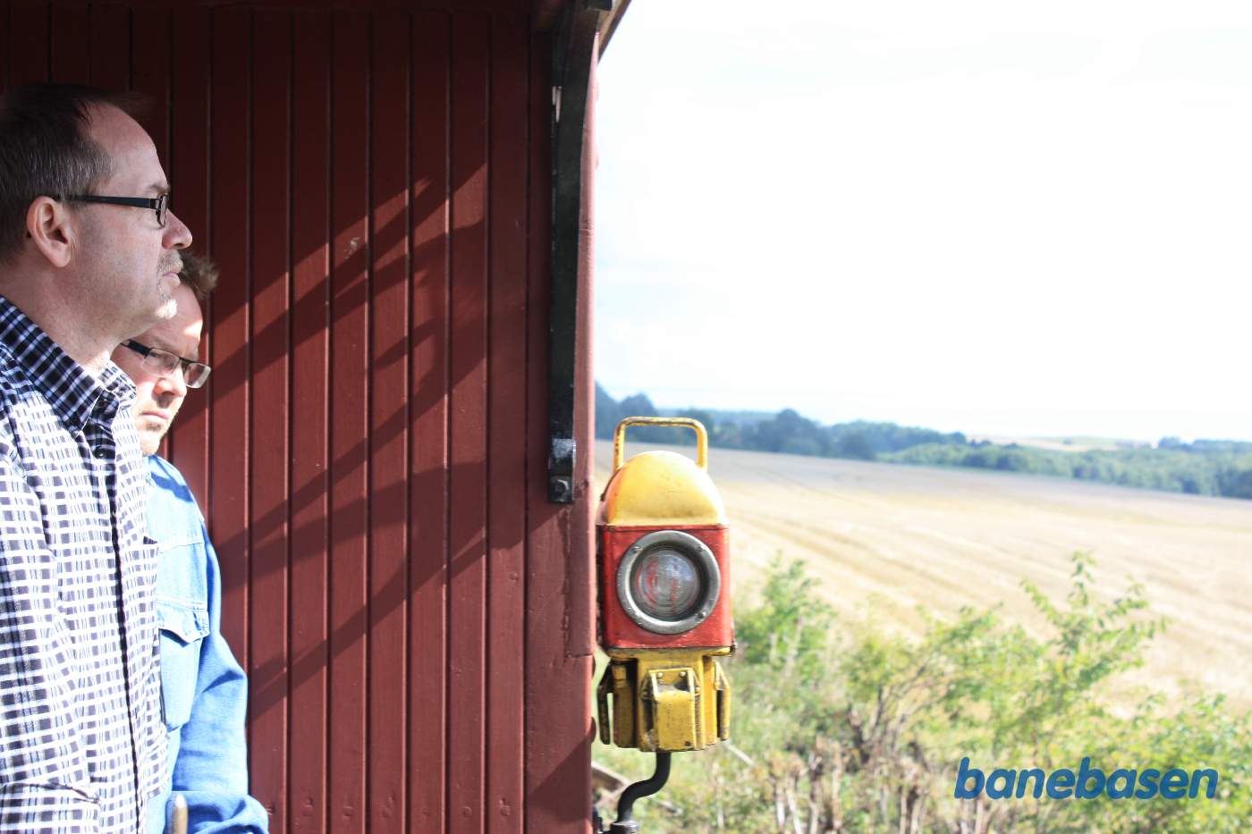 To rejsende på en endeperron. Slutlampen ses midt i billedet, så vi er på sidste vogn