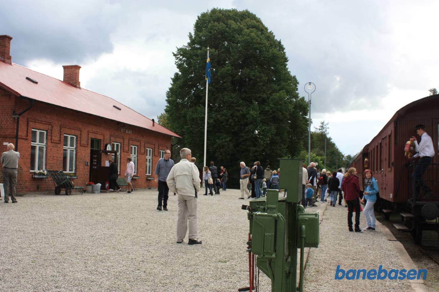 Toget er ankommet til endestationen og de rejsende stiger ud af toget, stationsbygningen inde til venstre