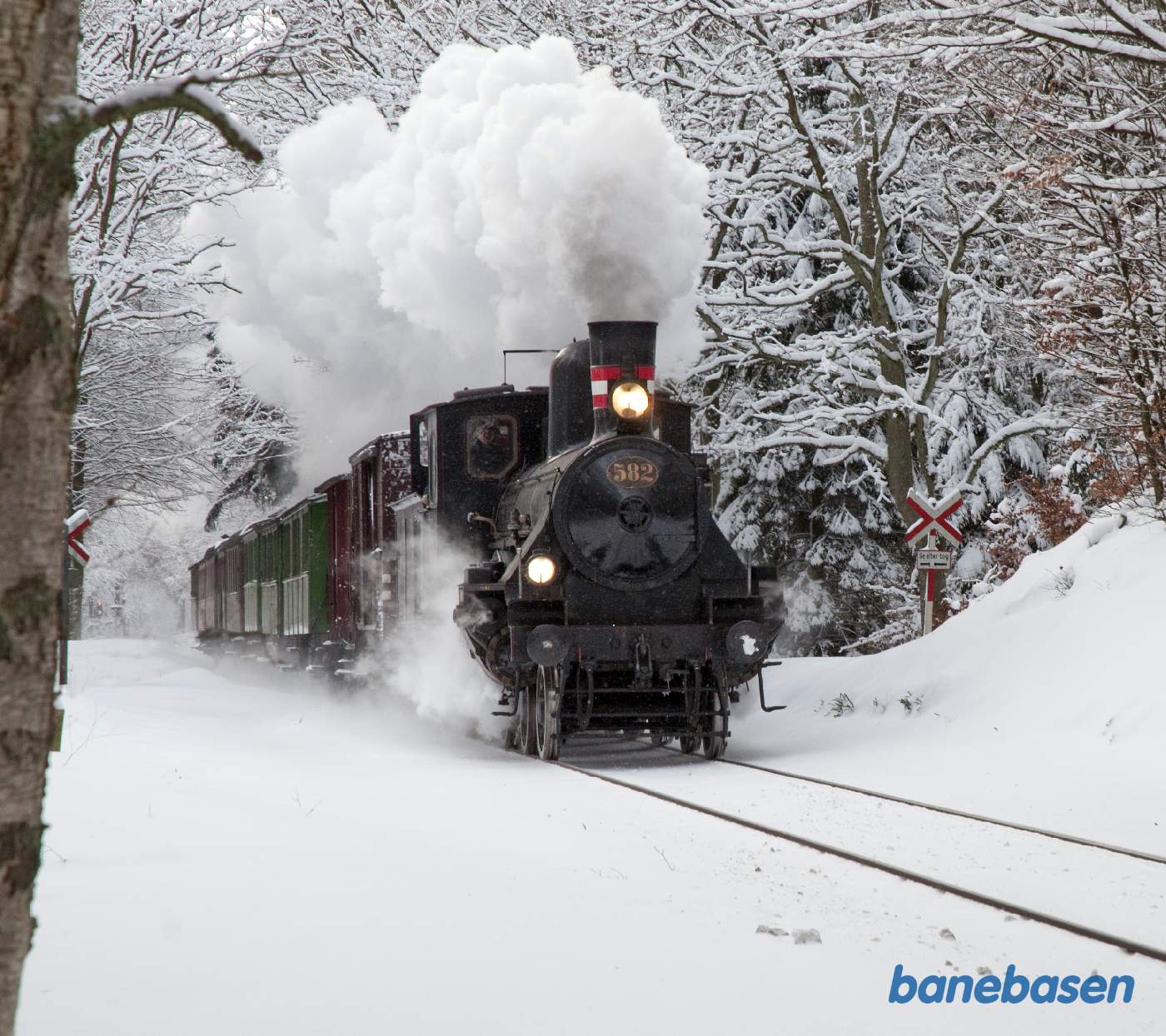 Juletoget fyldt med rejsende til Hellerup er på vej ud af Kagerup station, I-signalet til Kagerup ses ude i horisonten til venstre