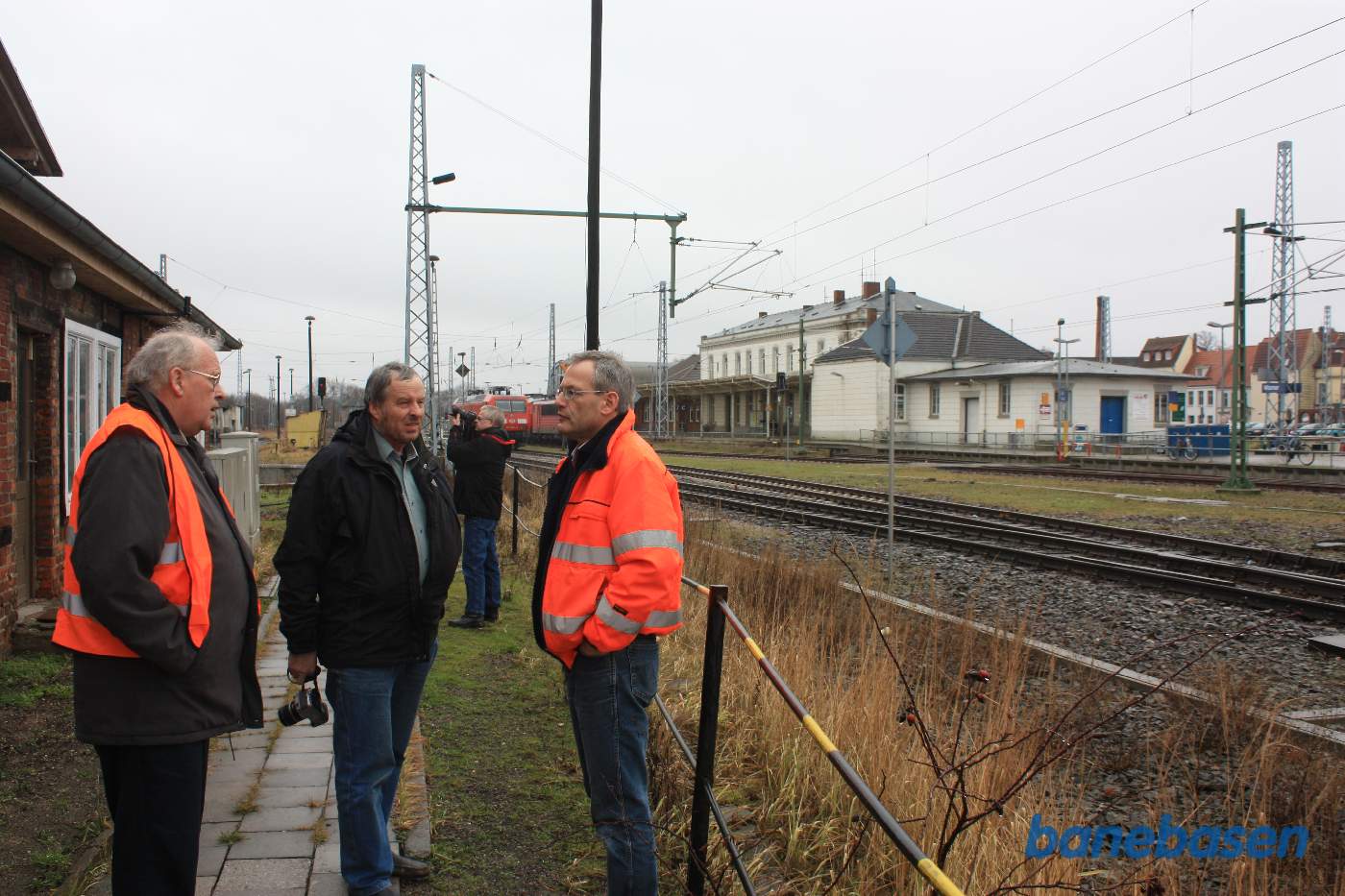 To gæster bydes velkommen af lederen til højre
