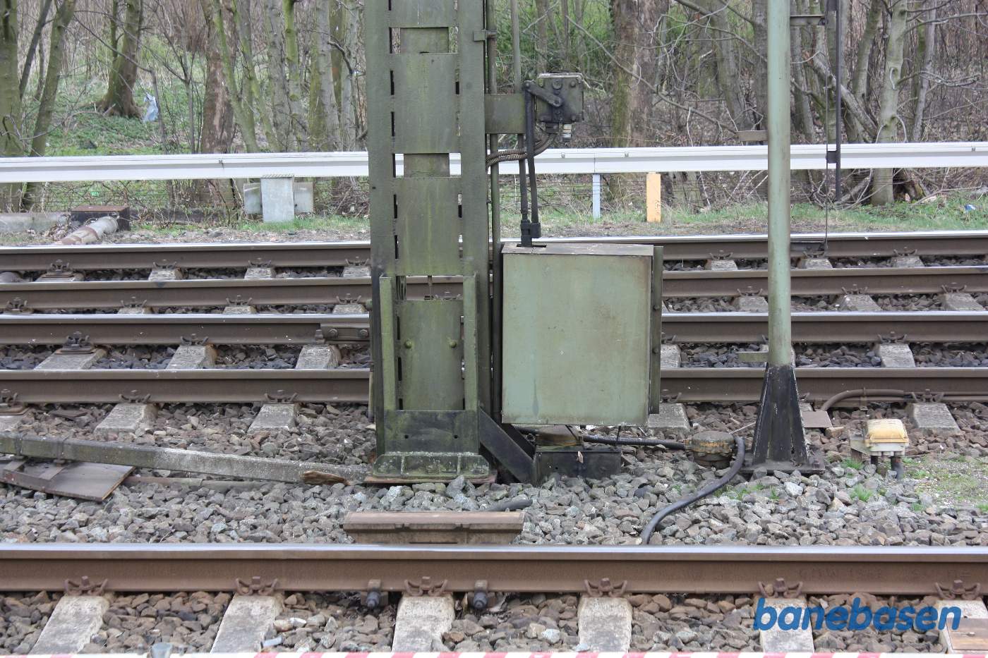 En INDUSI signalmagnet styret af et armsignal. Wiretrækket til signalet ligger i røret og man kan se wiren gå op i metalkassen