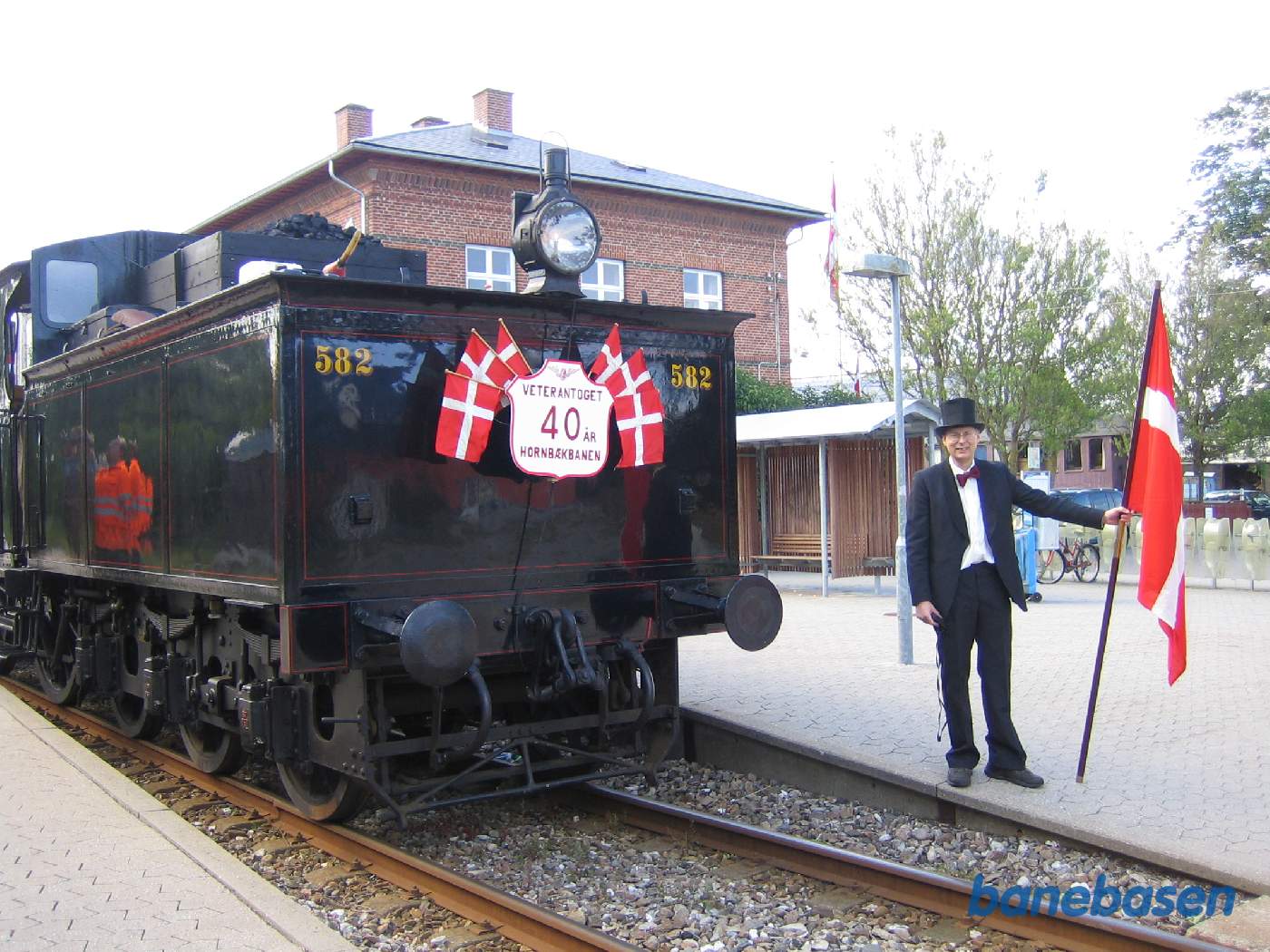 En af de festklædte klubmedlemmer med klubbens fane