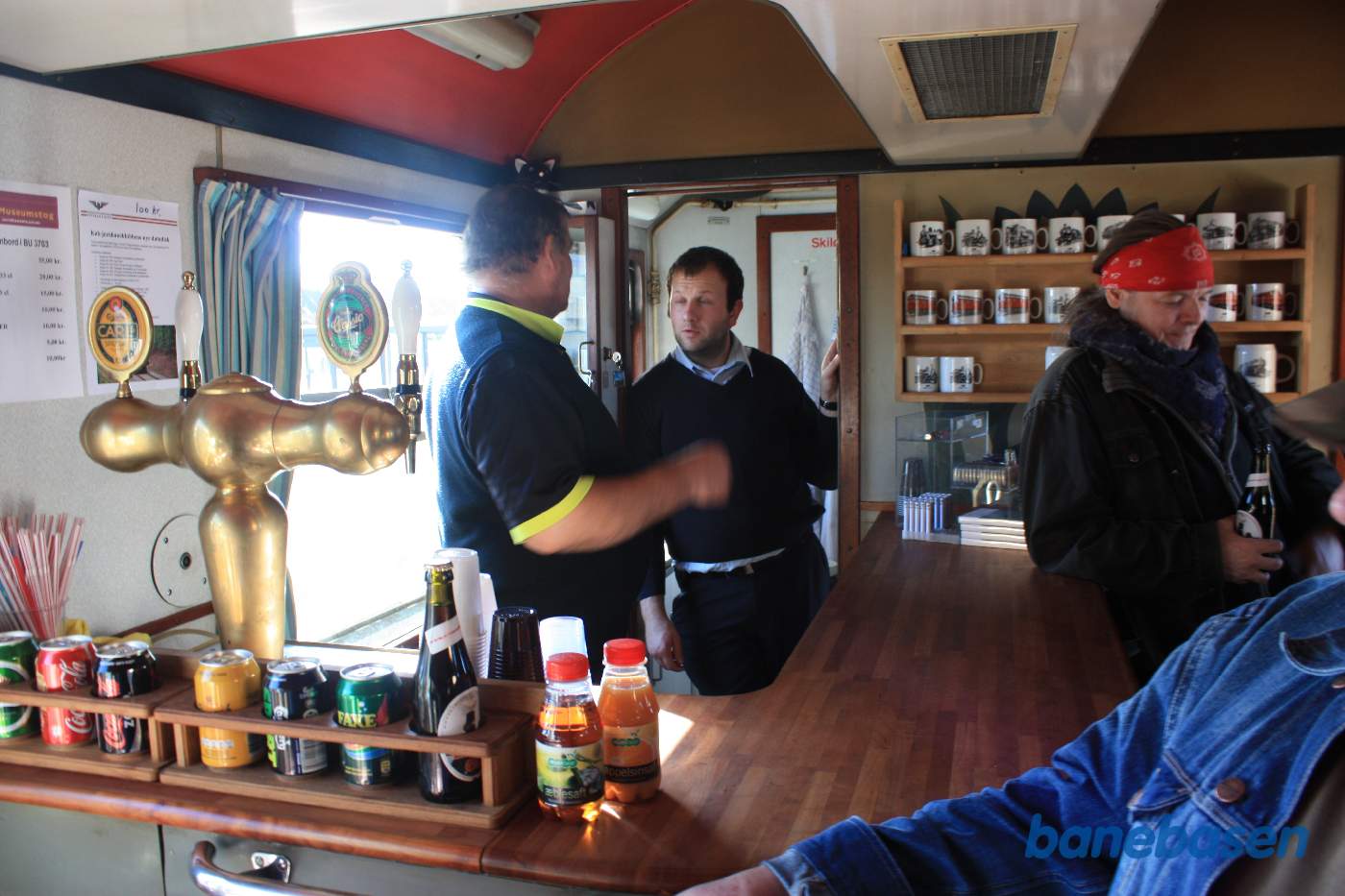 De to der betjener spisevognen har travlt, det er NSJK K-maskine øl der serveres