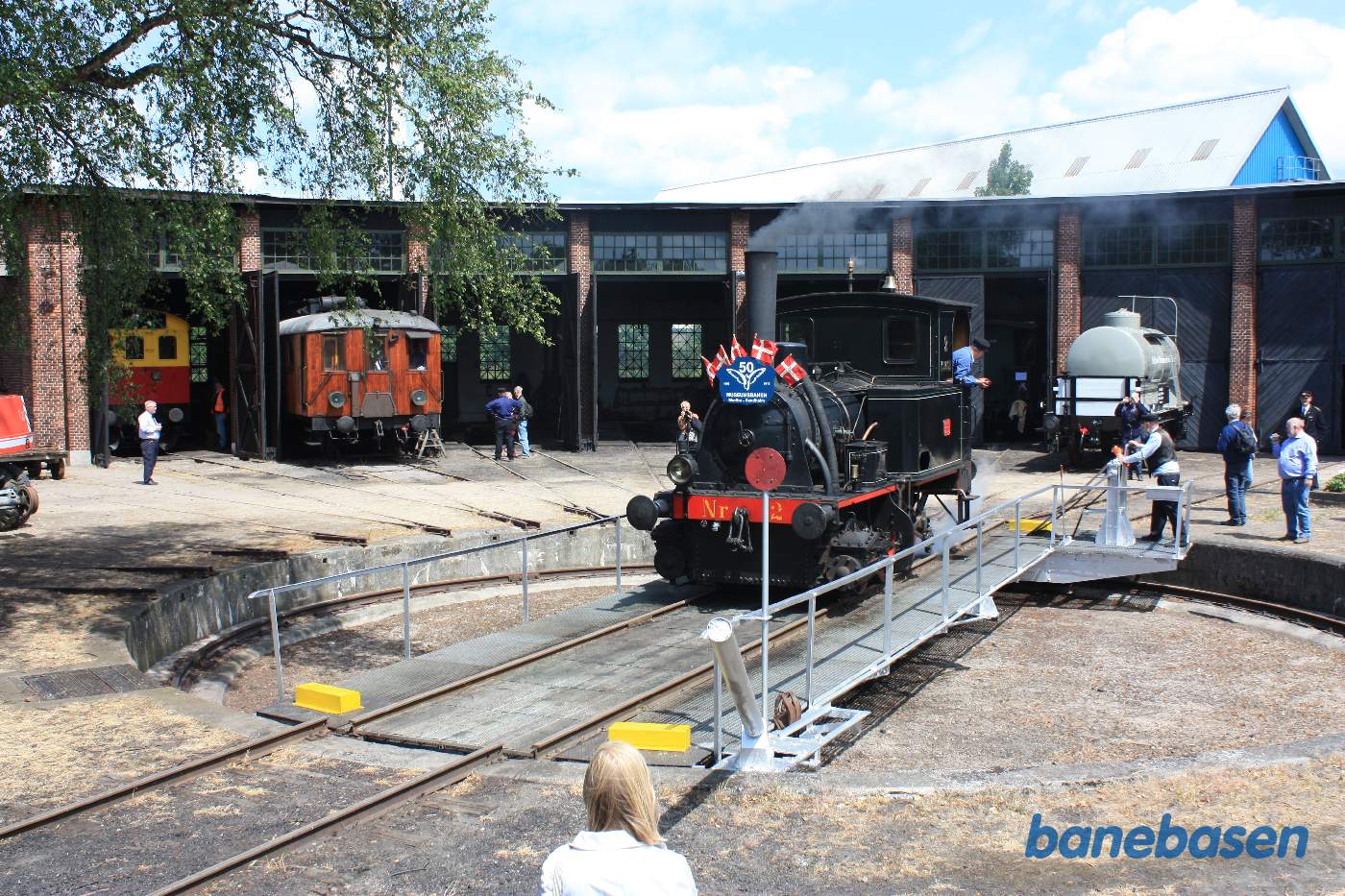 Det lille damplokomotiv holder på drejeskiven der er under bevægelse - håndbetjent Det lille damplokomotiv holder på drejeskiven der er under bevægelse - håndbetjent