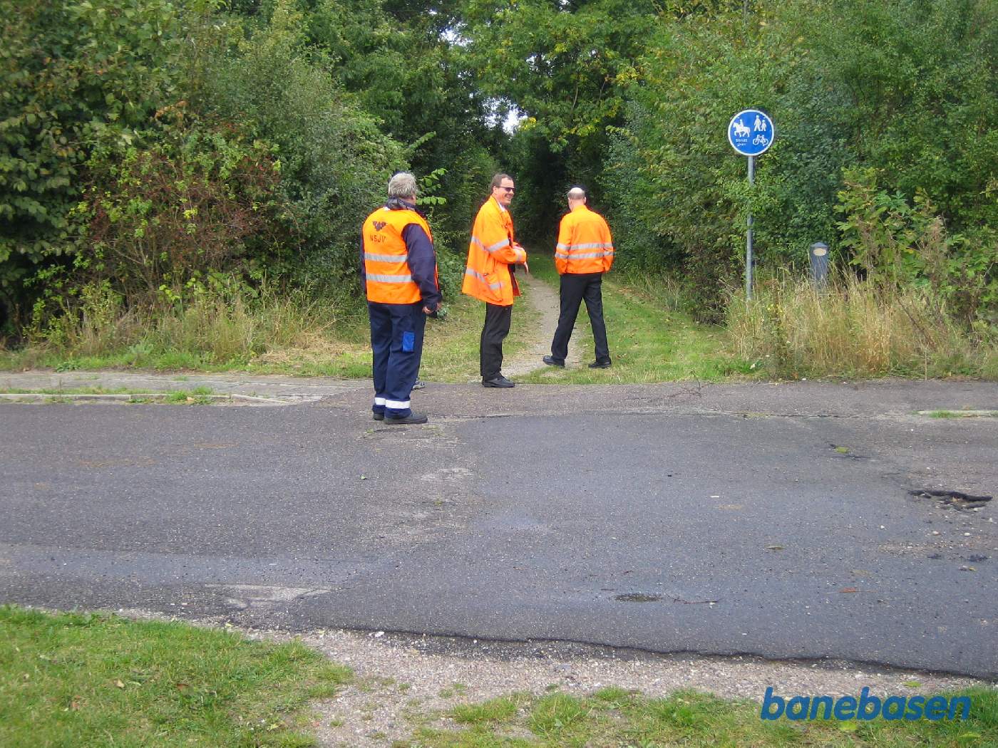 Et par klubmedlemmer kigger på stien der fører til den gamle Rødby Havn station