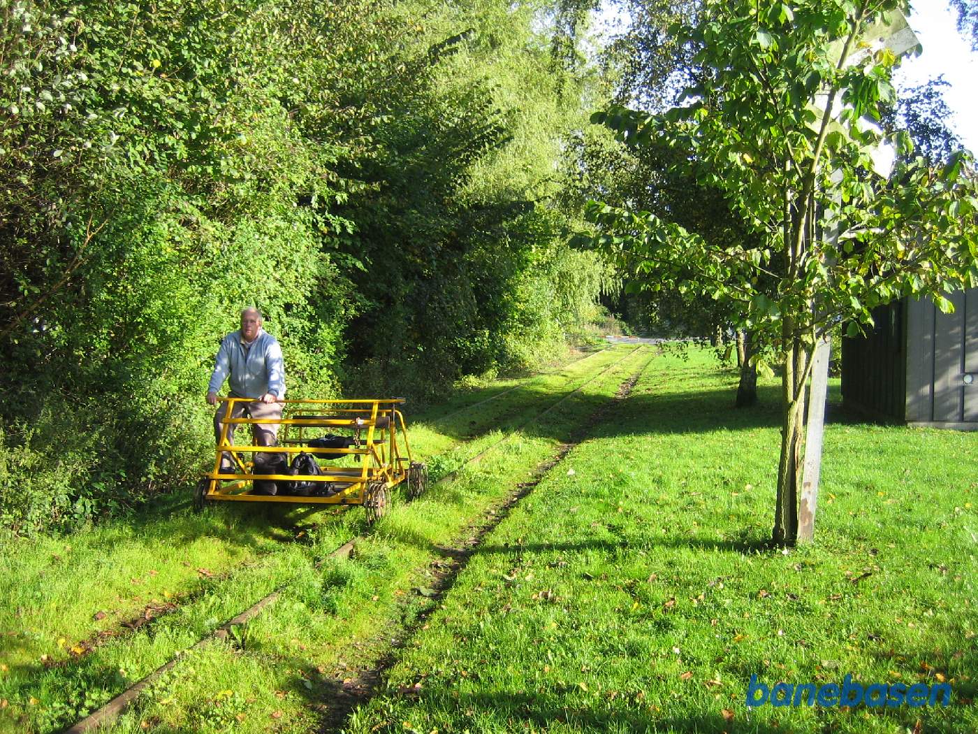 Skinnecyklen klar til at køre videre, stationsbygningen til højre bag træerne Skinnecyklen klar til at køre videre, stationsbygningen til højre bag træerne