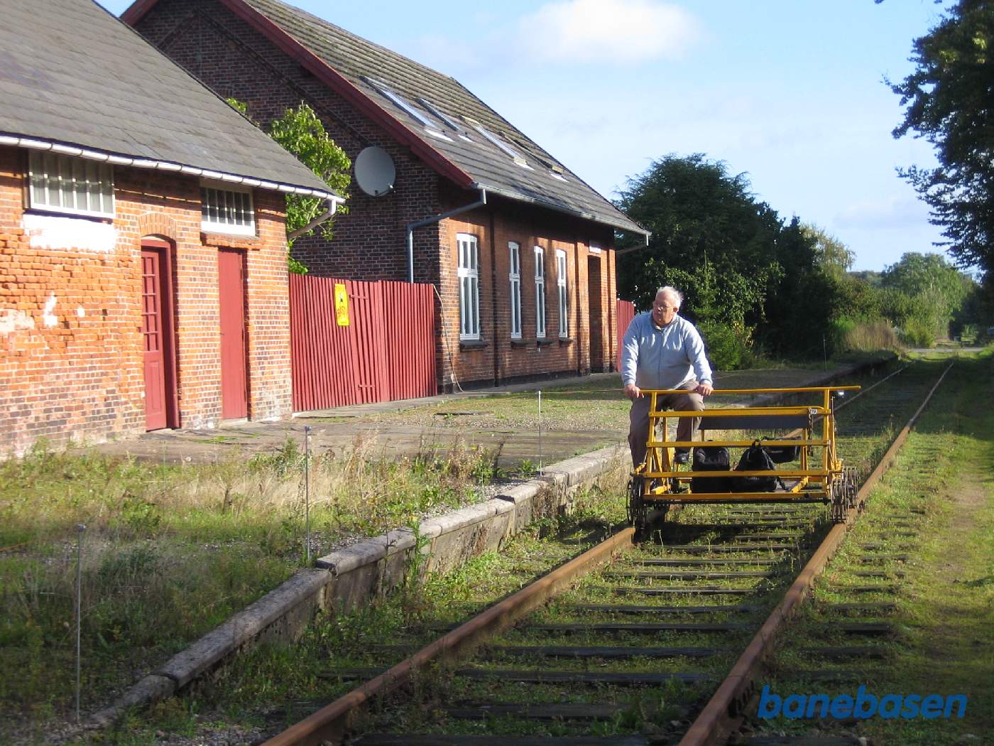 Skinnecyklen klar til at køre videre, stationsbygningen og varehuset til venstre