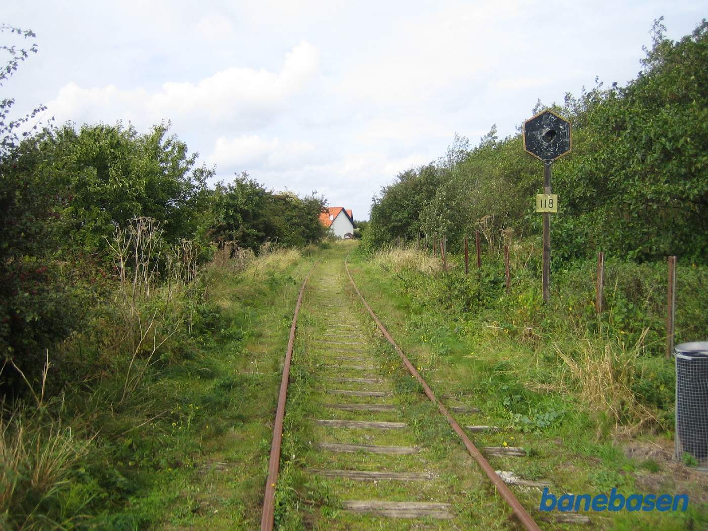 Kontrollys for overkørsel 118, Torø Huse Vej, og affaldsspand for bord-bænk inde til højre, lige efter sporskiftet til et nedlagt sidespor