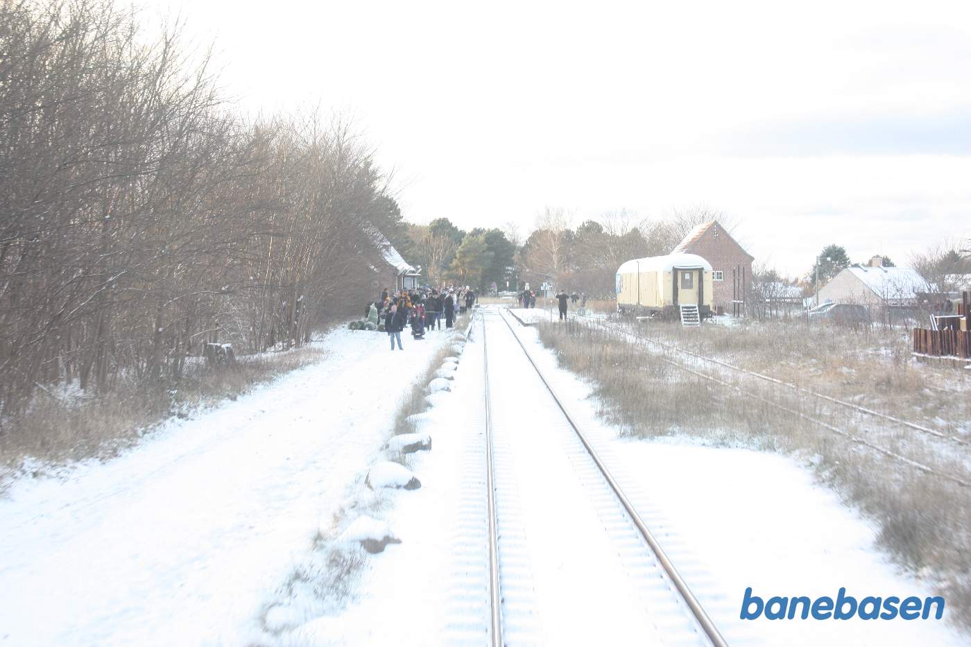 Juletoget på vej ind på stationen hvor gæsterne venter, til højre i spor 3 en gul postvogn, som den lokale teatergruppe havde ombygget til teater