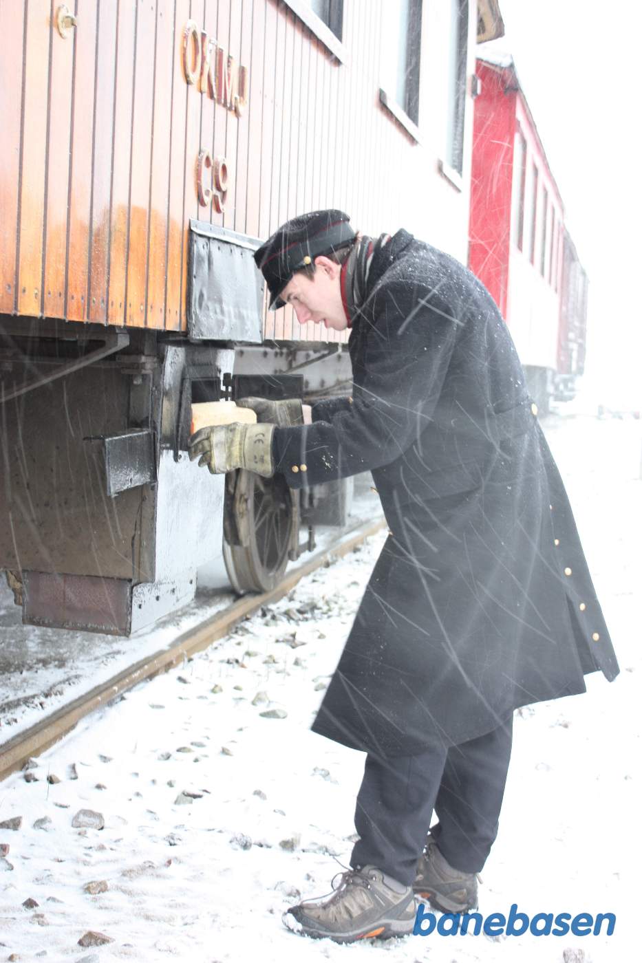Varmemesteren fyrer op i centralvarmefyret under vognen