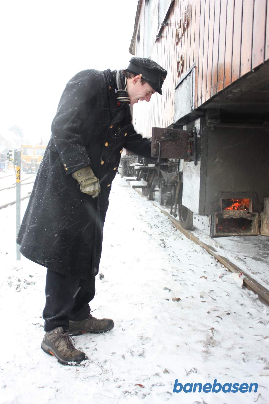 Varmemesteren fyrer op i centralvarmefyret under vognen Varmemesteren fyrer op i centralvarmefyret under vognen