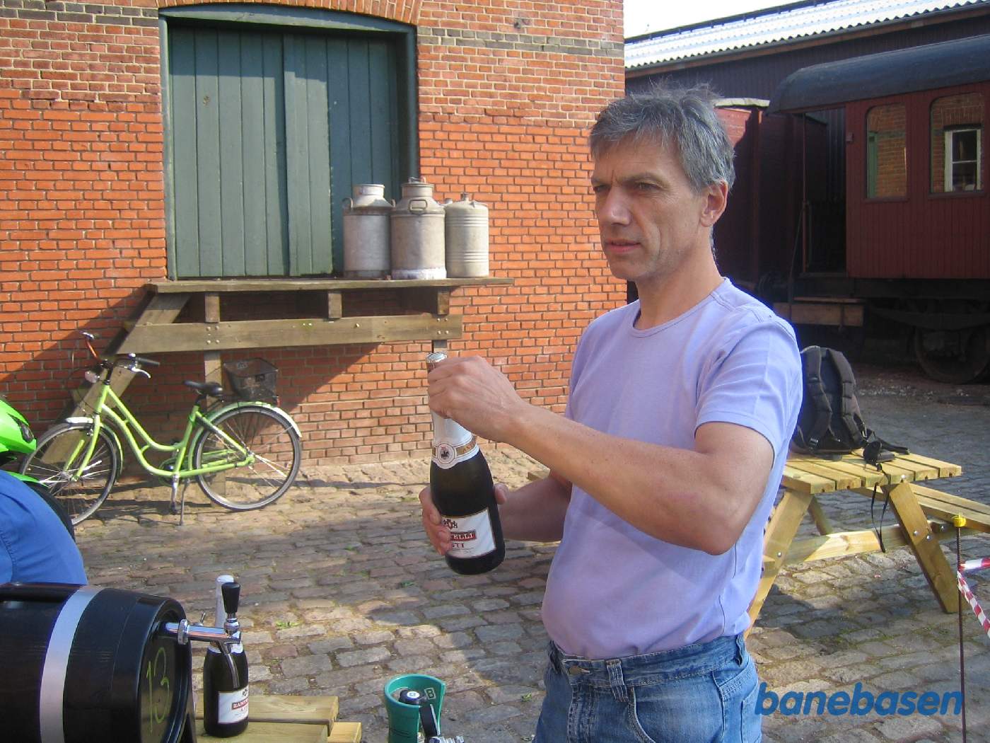 Så skal der festes. Den nye fyrbøder trækker en flaske vin op Så skal der festes. Den nye fyrbøder trækker en flaske vin op