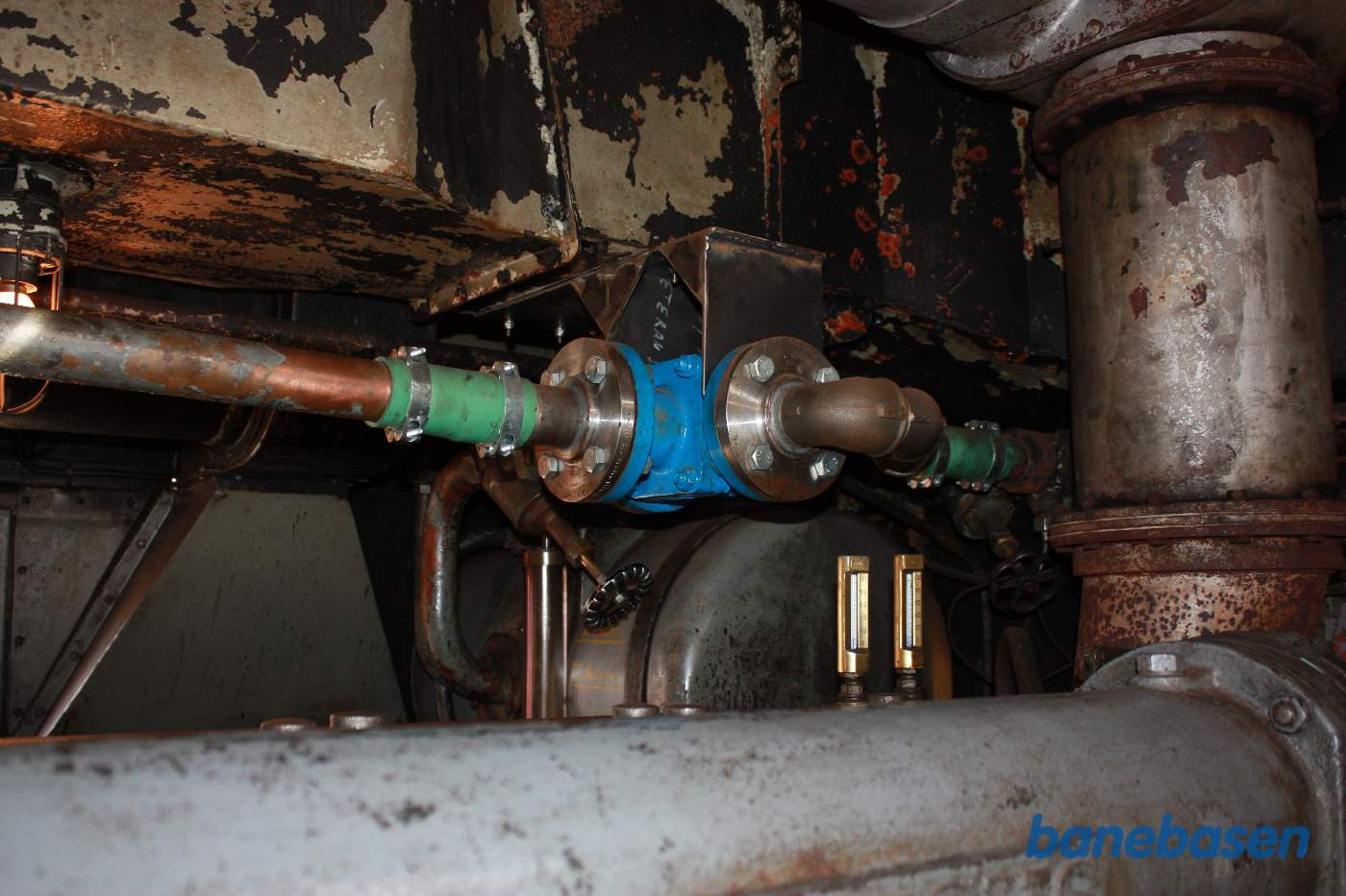 Den nye termostatstyring af kølevandet ses midt i billedet. Vandet kommer fra venstre og kan enten løbe ud i højre side og op på taget eller tilbage til ekspandsbeholderen, der ses i baggrunden