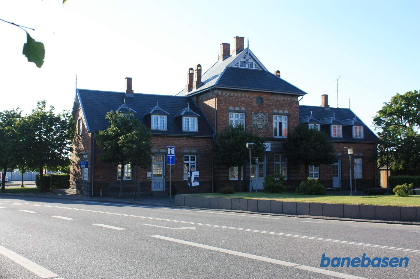 Stationsbygningen set fra gaden og forpladsen