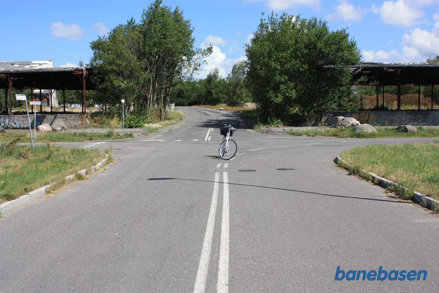 Vi står på Kaj Mogensens Vej og kigger på tværvejen Kanegårdsvej, som banen løb langs, præcist hvor cyklen er parkeret. Til venstre mod Rønne og til højre mod Nexø Vi står på Kaj Mogensens Vej og kigger på tværvejen Kanegårdsvej, som banen løb langs, præcist hvor cyklen er parkeret. Til venstre mod Rønne og til højre mod Nexø