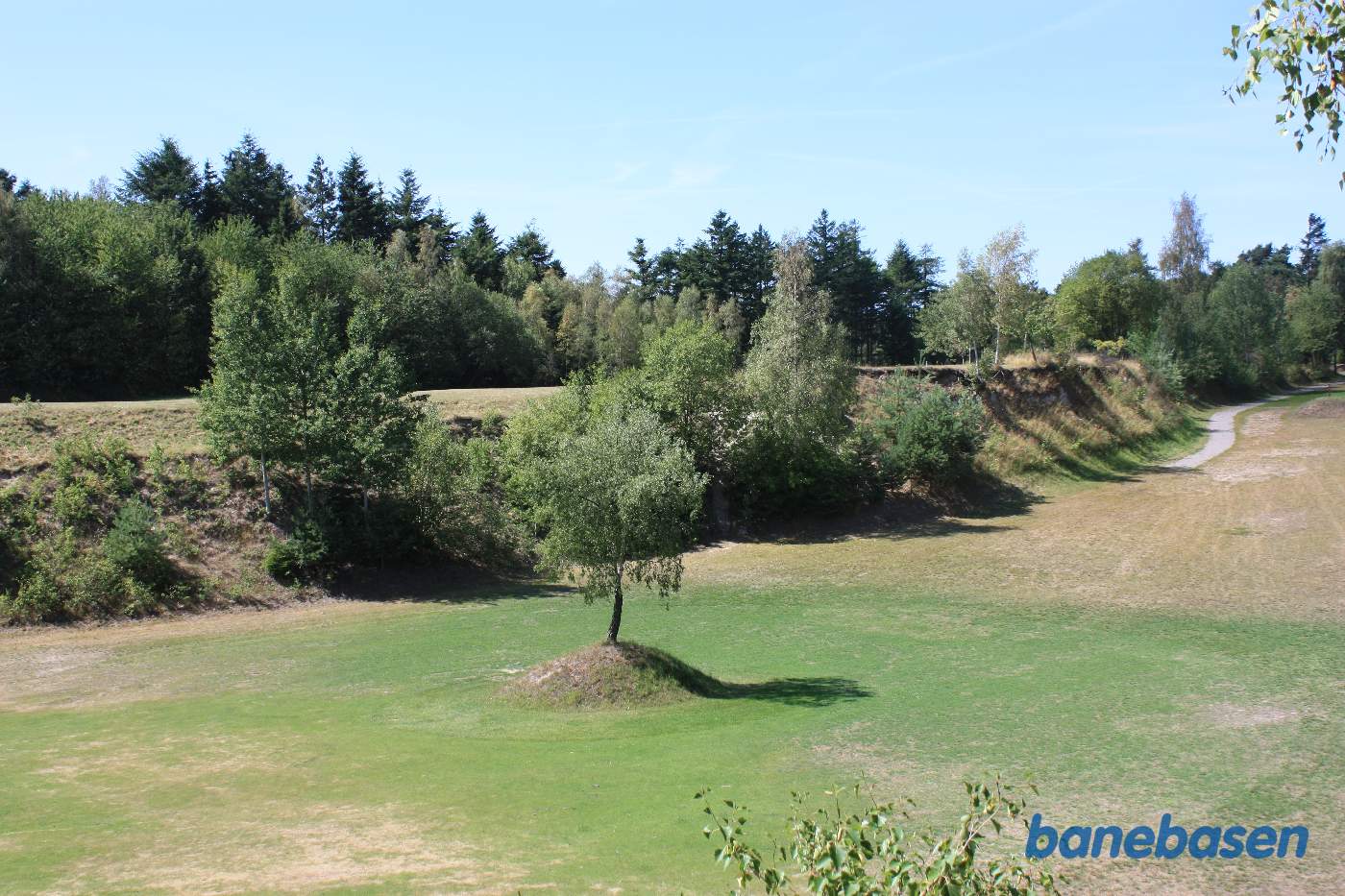 Her er lavet naturgenopretning og banens tracé er fjernet, den har formentlig ligget over til venstre. Vi kigger i retning af Rønne Her er lavet naturgenopretning og banens tracé er fjernet, den har formentlig ligget over til venstre. Vi kigger i retning af Rønne