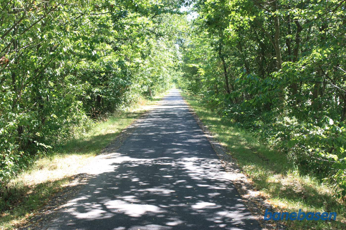 Nu kommer der et langt lige stykke bane igennem et flot landskab. Vi kigger i retning mod Nexø Nu kommer der et langt lige stykke bane igennem et flot landskab. Vi kigger i retning mod Nexø