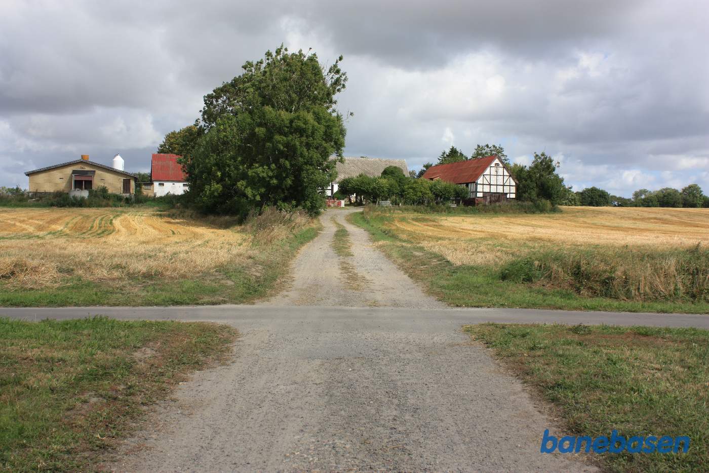 Vi står på Rønnevej og kigger op mod den store gård, hvor banen krydsede vejen. Rønne til venstre og Nexø til højre Vi står på Rønnevej og kigger op mod den store gård, hvor banen krydsede vejen. Rønne til venstre og Nexø til højre