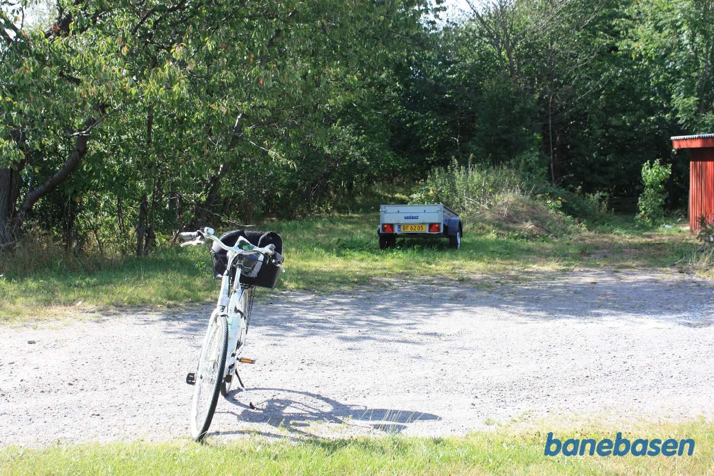Vi står på Rønnevej og cyklen markerer hvor de 2 baner krydsede den lille sidevej. Vi kigger i retning mod Rønne