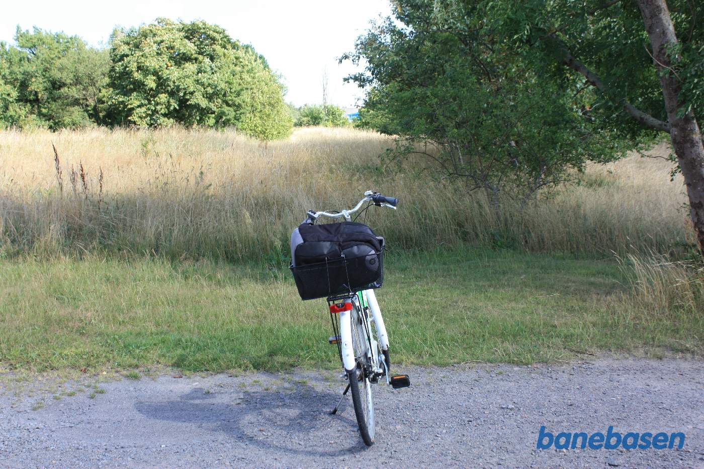 Vi står på Rønnevej og cyklen markerer hvor de 2 baner krydsede den lille sidevej. Vi kigger i retning mod Nexø