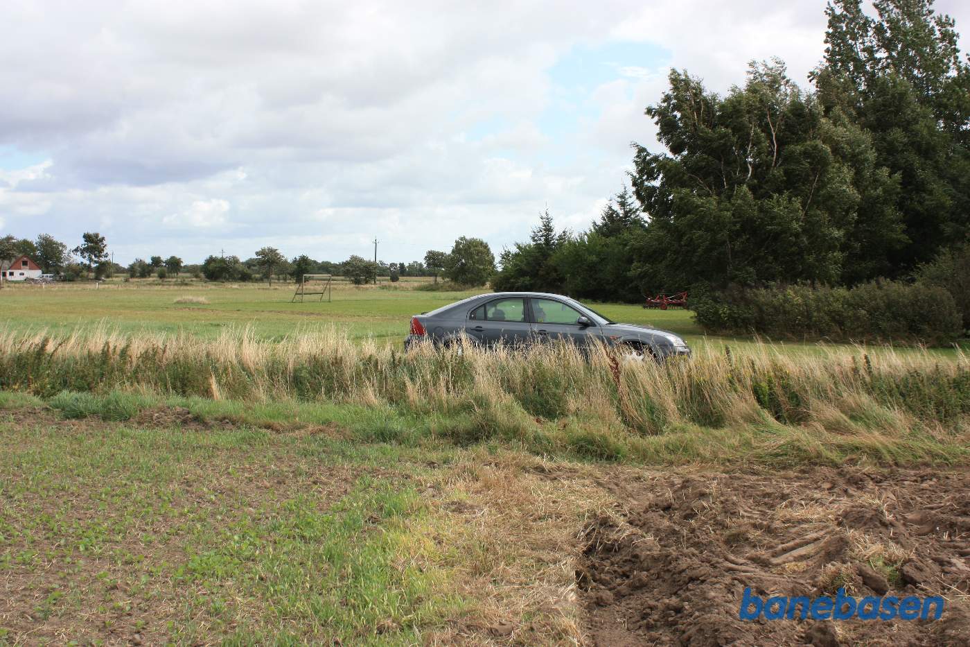 Vi er på Dalegårdsvej og bilen markerer hvor banen krydsede vejen, vi ser i retning mod Nexø Vi er på Dalegårdsvej og bilen markerer hvor banen krydsede vejen, vi ser i retning mod Nexø