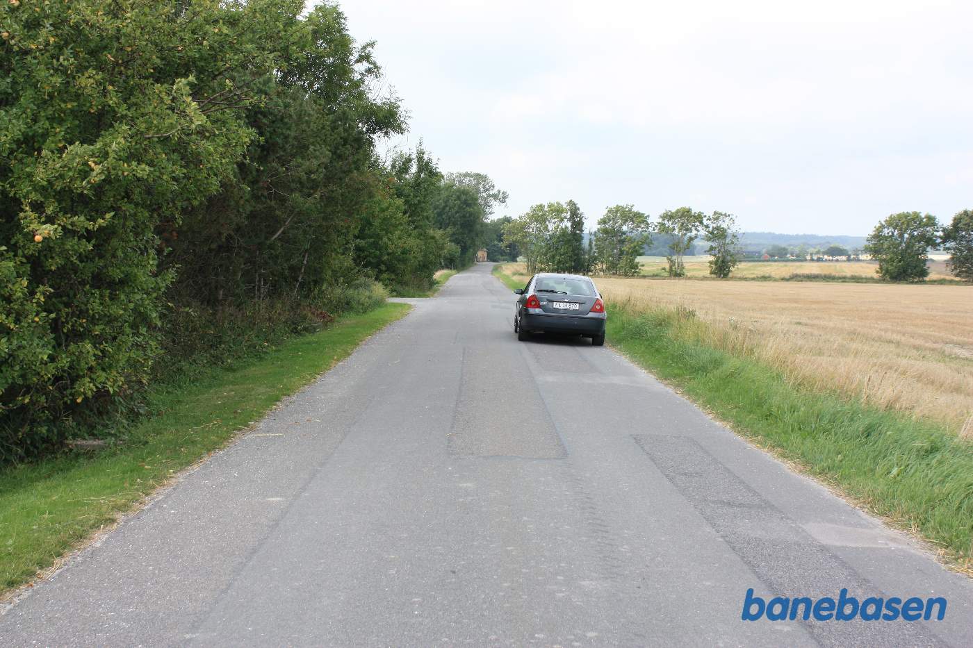 Vi er på Brandsgårdsvejen og bilen markerer, hvor banen krydsede vejen, Rønne til venstre og Nexø til højre. Sidevejen til venstre går op til stationsbygningen