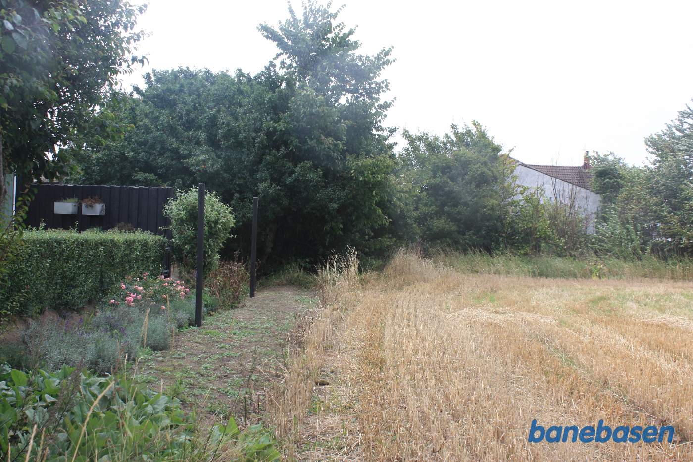 Banen løb til højre for hækken og ind i byen, hvor træerne nu står Banen løb til højre for hækken og ind i byen, hvor træerne nu står