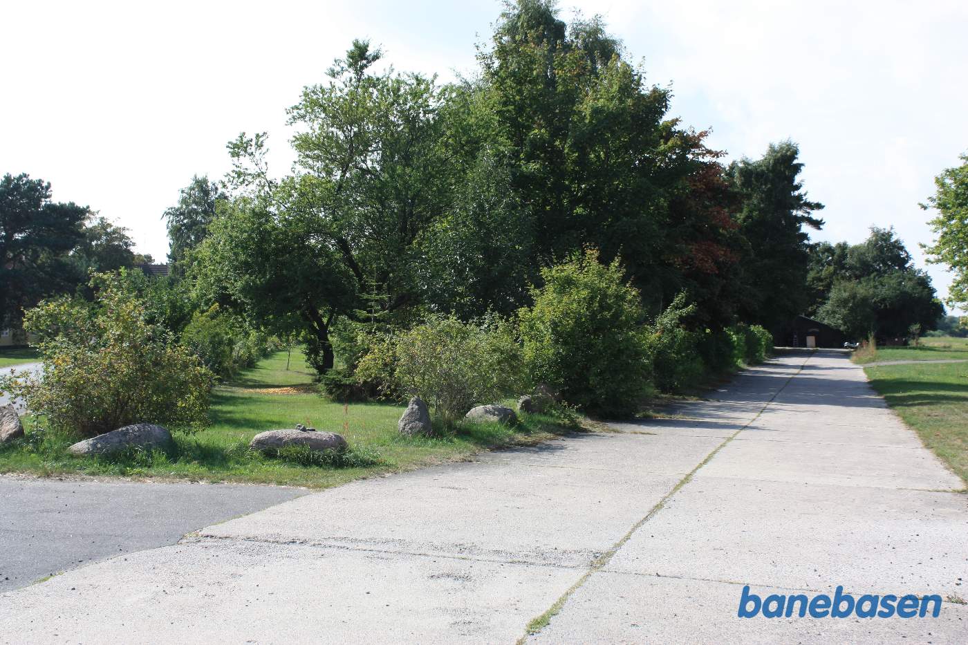 Jernbaneområdet lå til venstre for betongaden der er banens gamle læssevej. Pakhuset fra banens tid ses nede for enden af læssevejen Jernbaneområdet lå til venstre for betongaden der er banens gamle læssevej. Pakhuset fra banens tid ses nede for enden af læssevejen