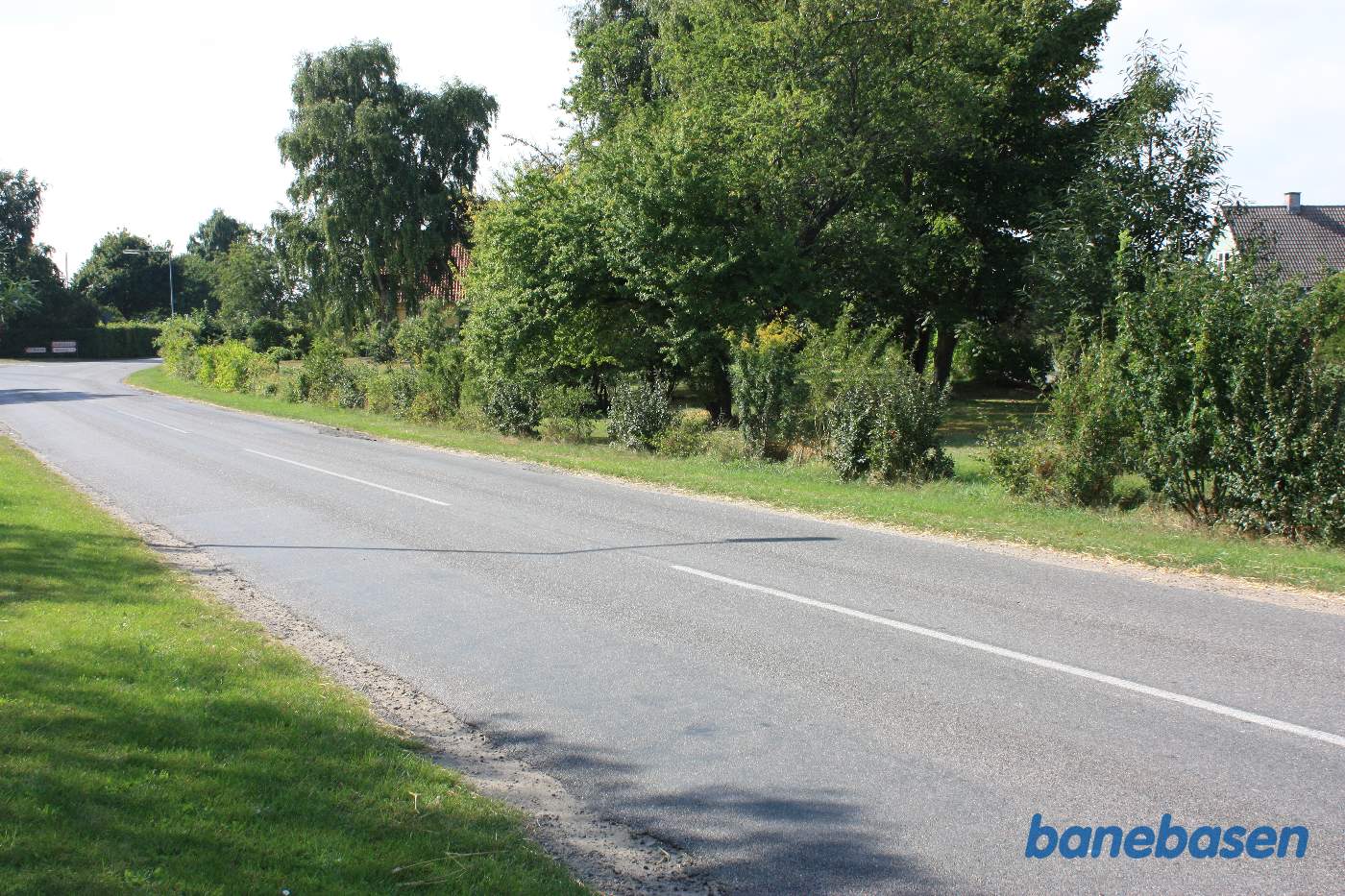 Vi ser ind mod stationen, hvis tag ses bag træerne