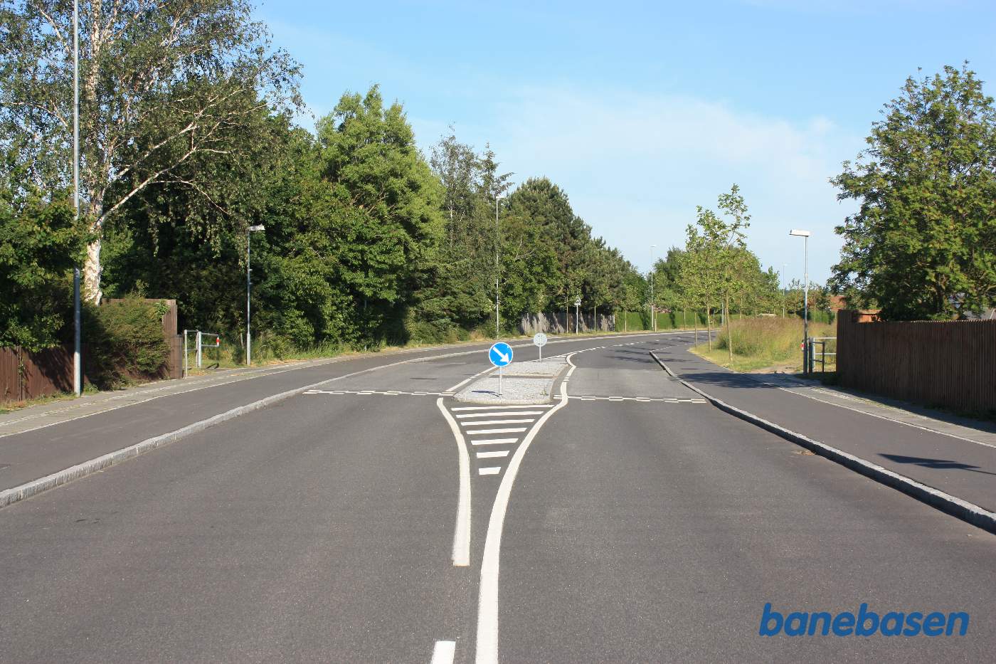 Vi er på Nordre Ringvej og hellen markerer der hvor banen i sin tid gik. Banestien ses til begge sider, mod Sandvig til venstre og Rønne til højre