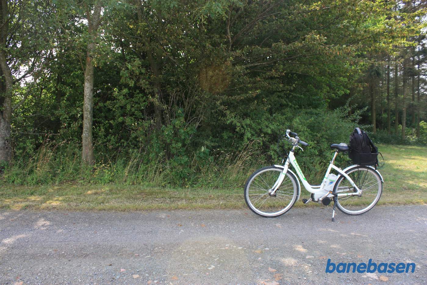 Vi står på alléen op til gården. Cyklen markerer hvor banen krydsede vejen. Vi kigger mod Rønne Vi står på alléen op til gården. Cyklen markerer hvor banen krydsede vejen. Vi kigger mod Rønne
