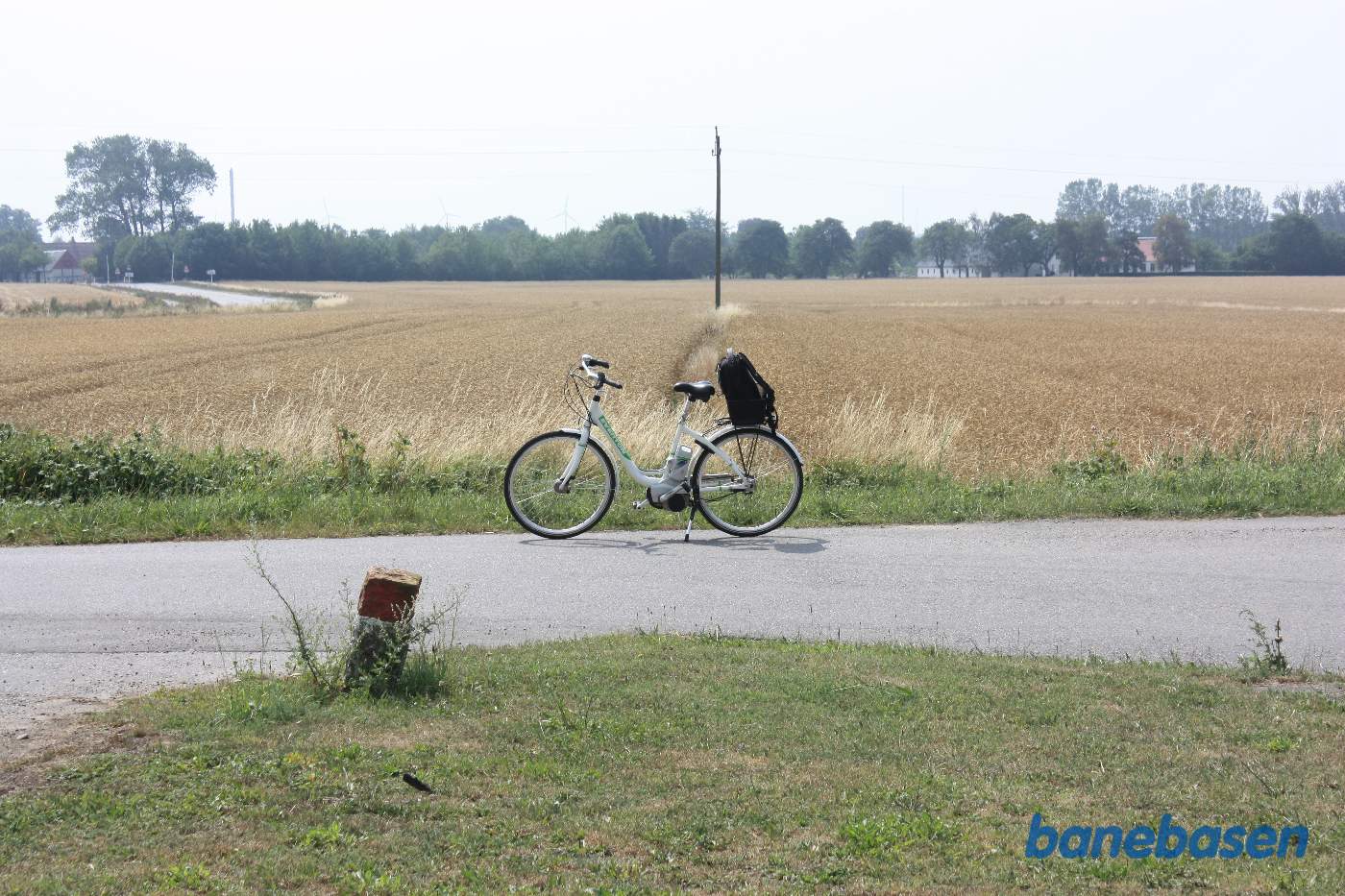 Vi står på Vallevadsvej hvor cyklen markerer hvor banen gik, vi kigger mod Rønne og gården ses til højre. Banen gik omtrent der hvor el-masten står Vi står på Vallevadsvej hvor cyklen markerer hvor banen gik, vi kigger mod Rønne og gården ses til højre. Banen gik omtrent der hvor el-masten står