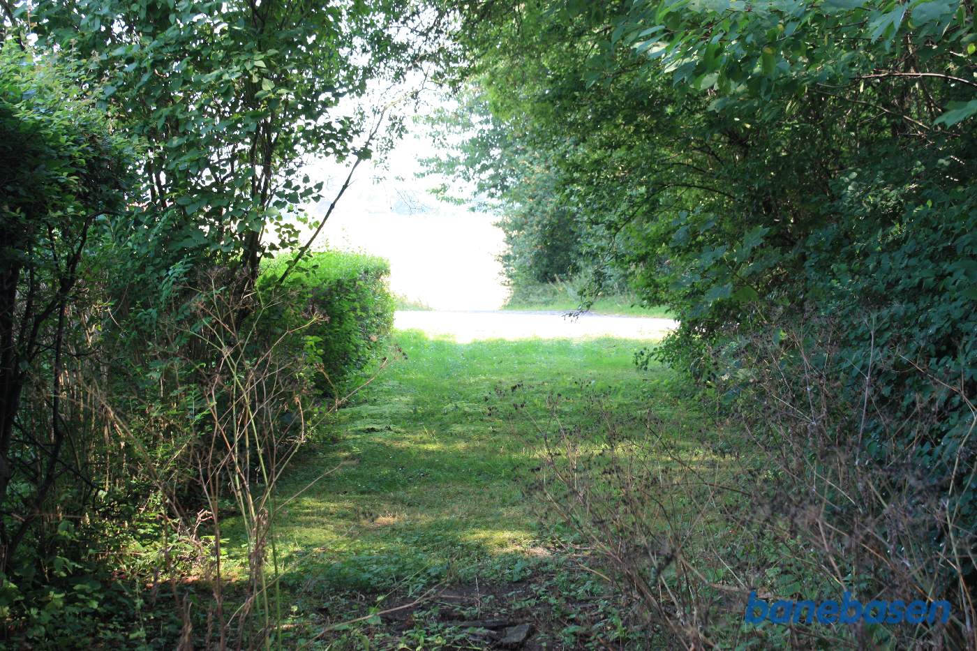 Vi står på banens tracé og kigger mod Sandvig. Vejen i forgrunden er Aagaardsvej Vi står på banens tracé og kigger mod Sandvig. Vejen i forgrunden er Aagaardsvej