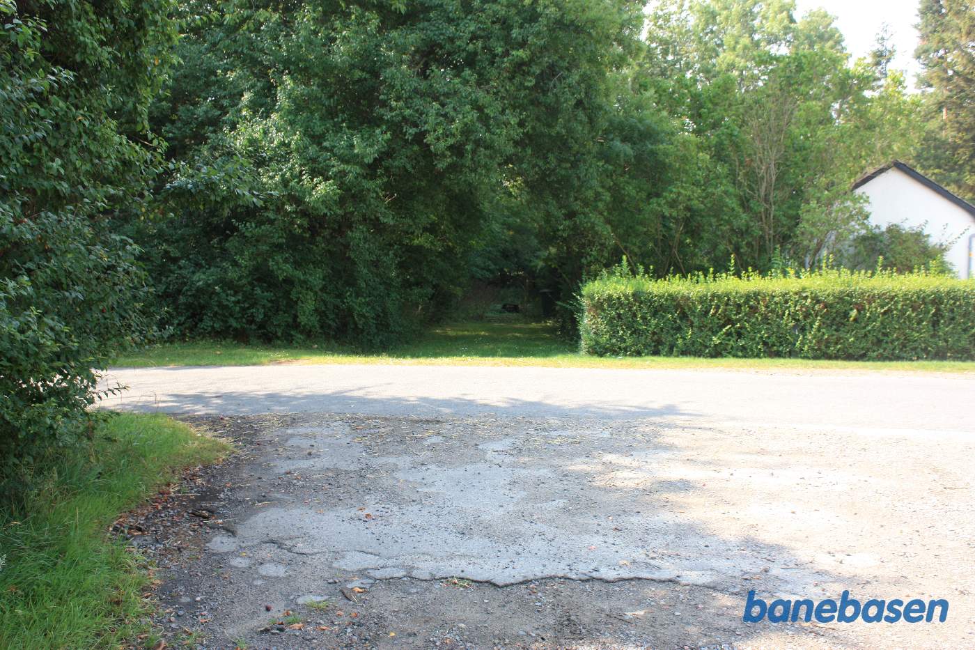 Vi står ved Aagaardsvej og kigger mod Rønne. Banen gik ind i indkørslen mellem hækken og træerne Vi står ved Aagaardsvej og kigger mod Rønne. Banen gik ind i indkørslen mellem hækken og træerne