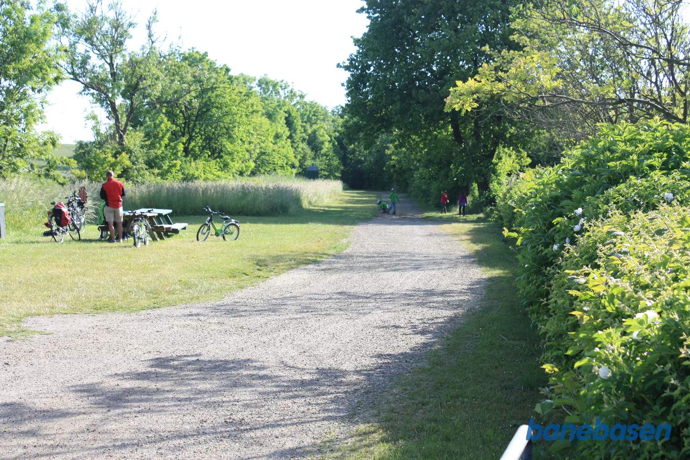 Vi står på Dammegårdsvej og kigger mod Rønne. Perron og læskur til højre for banen, omtrent der hvor de 4 børn leger Vi står på Dammegårdsvej og kigger mod Rønne. Perron og læskur til højre for banen, omtrent der hvor de 4 børn leger