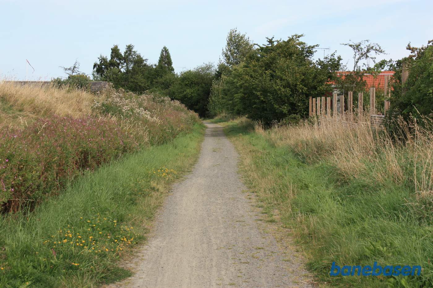Banen fortsætter forbi sommerhusene til højre i retning mod Sandvig Banen fortsætter forbi sommerhusene til højre i retning mod Sandvig