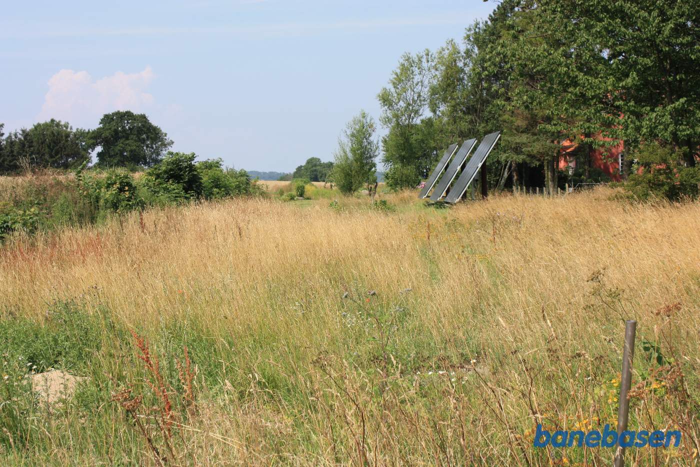 Vi er på Kåsevej og kigger ind på stationsområdet. Stationsbygningen til højre dækket af træer. Vi kigger mod Sandvig Vi er på Kåsevej og kigger ind på stationsområdet. Stationsbygningen til højre dækket af træer. Vi kigger mod Sandvig