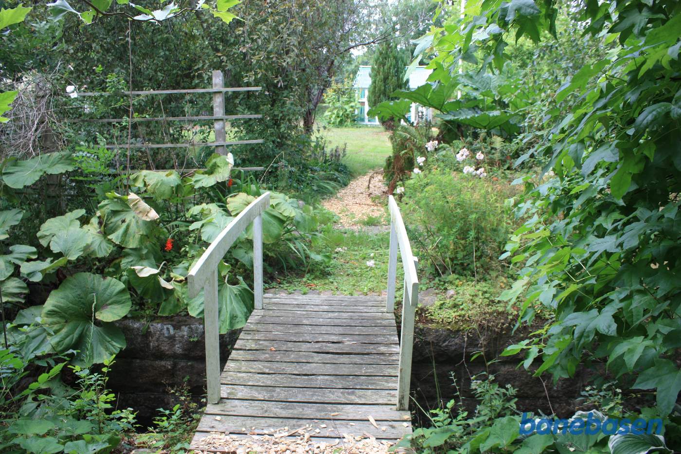 Inde i haven finder vi denne søde lille bro, men stenfundamentet viser, at banen gik her. Vi ser mod Gudhjem