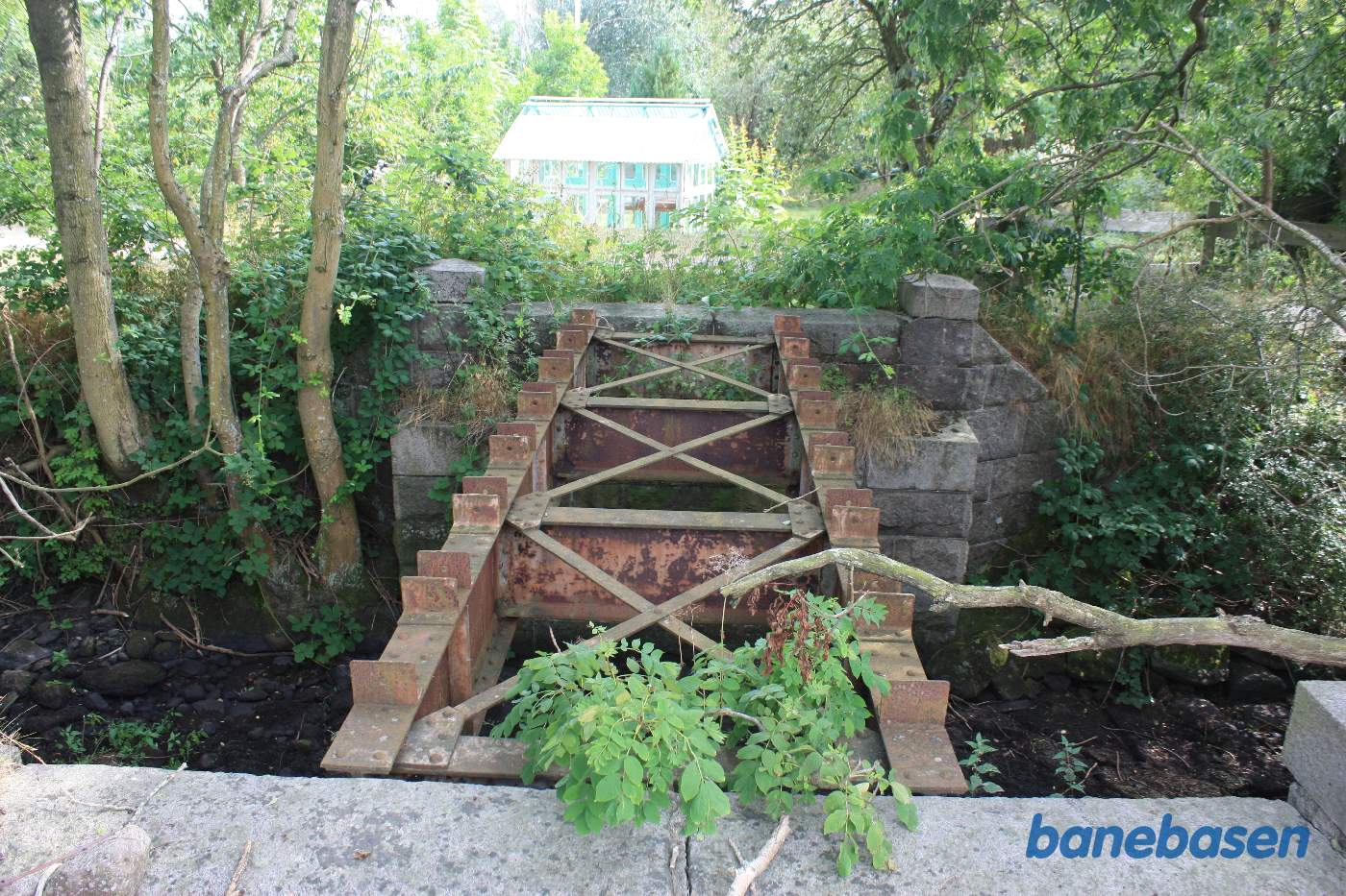 Vi står ved broen over Læså og kigger ind i haven i retning mod Aakirkeby