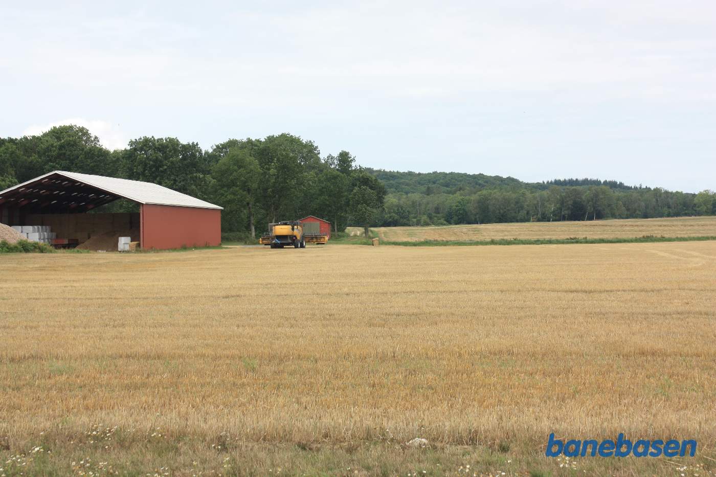 Vi står i et markskel og kigger mod Gudhjem. Banen gik midt i billedet og fortsatte ad de to hjulspor der ses efter laden Vi står i et markskel og kigger mod Gudhjem. Banen gik midt i billedet og fortsatte ad de to hjulspor der ses efter laden