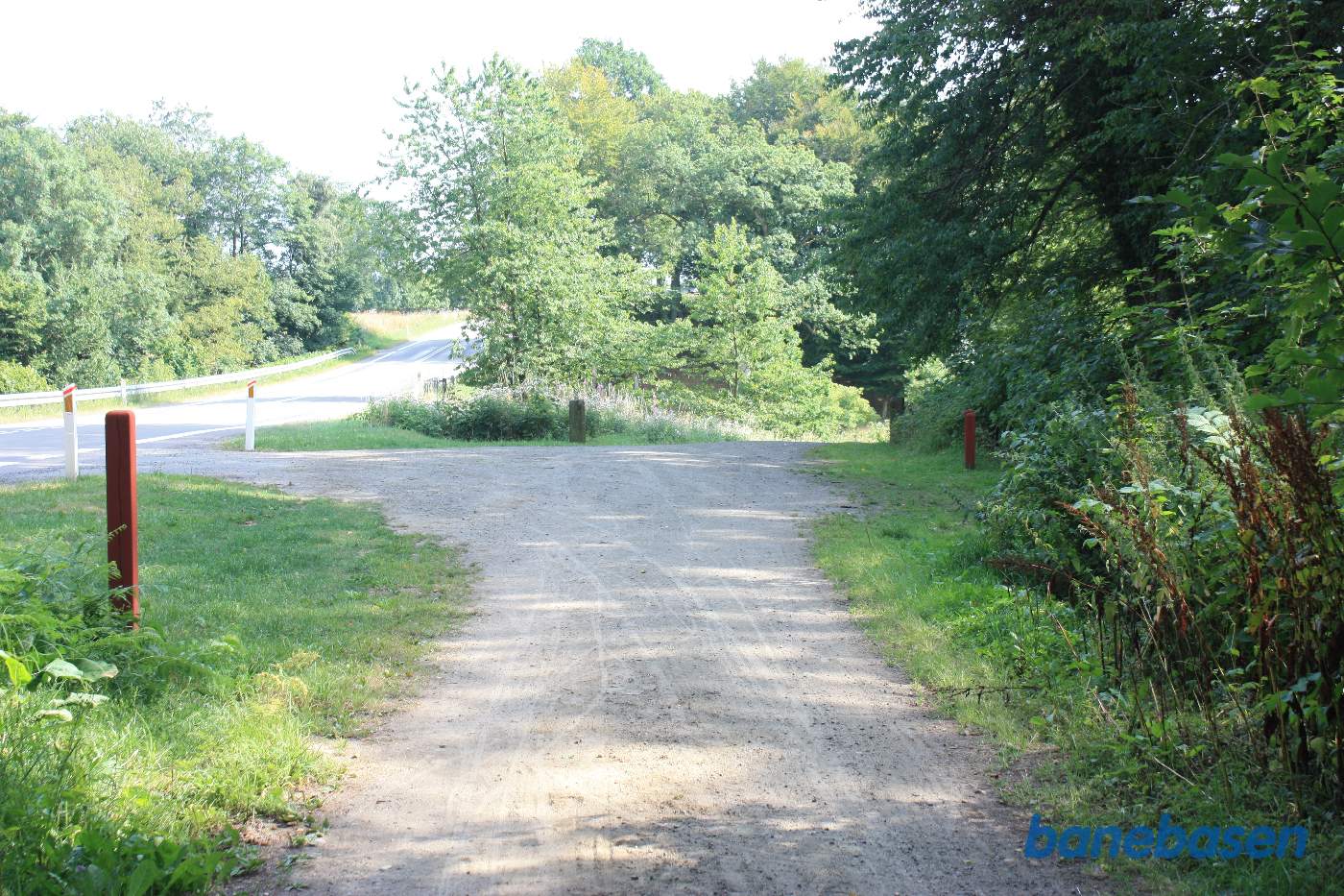 Vi står på banestien og kigger på grusvejen ned til Rømersdal gården. Vi kigger mod Aakirkeby Vi står på banestien og kigger på grusvejen ned til Rømersdal gården. Vi kigger mod Aakirkeby