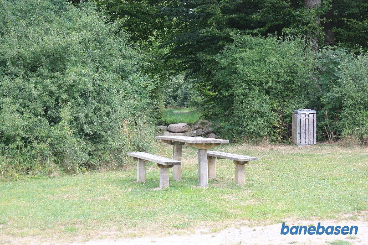 Banen gik igennem hullet og ind i skoven i en meget stor blød venstrekurve Banen gik igennem hullet og ind i skoven i en meget stor blød venstrekurve