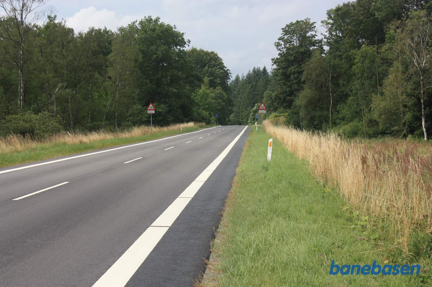 Her krydsede banen Segenvej. På grund af den spidse vinkel mellem vej og bane, fik vejen ved banens anlæg, et par sving, så bane og vej kom vinkelret på hinanden. Vi kigger mod Aakirkeby