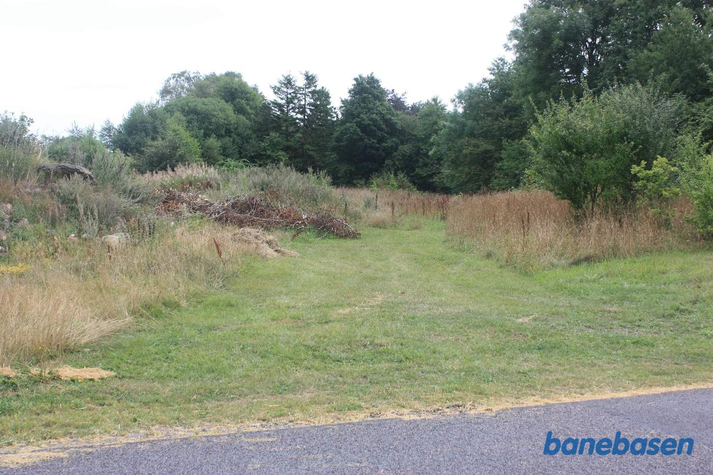 Vi står på Aaløsevej og kigger mod Gudhjem. Banen gik i en lige linje midt i billedet, ind på Aaløse station