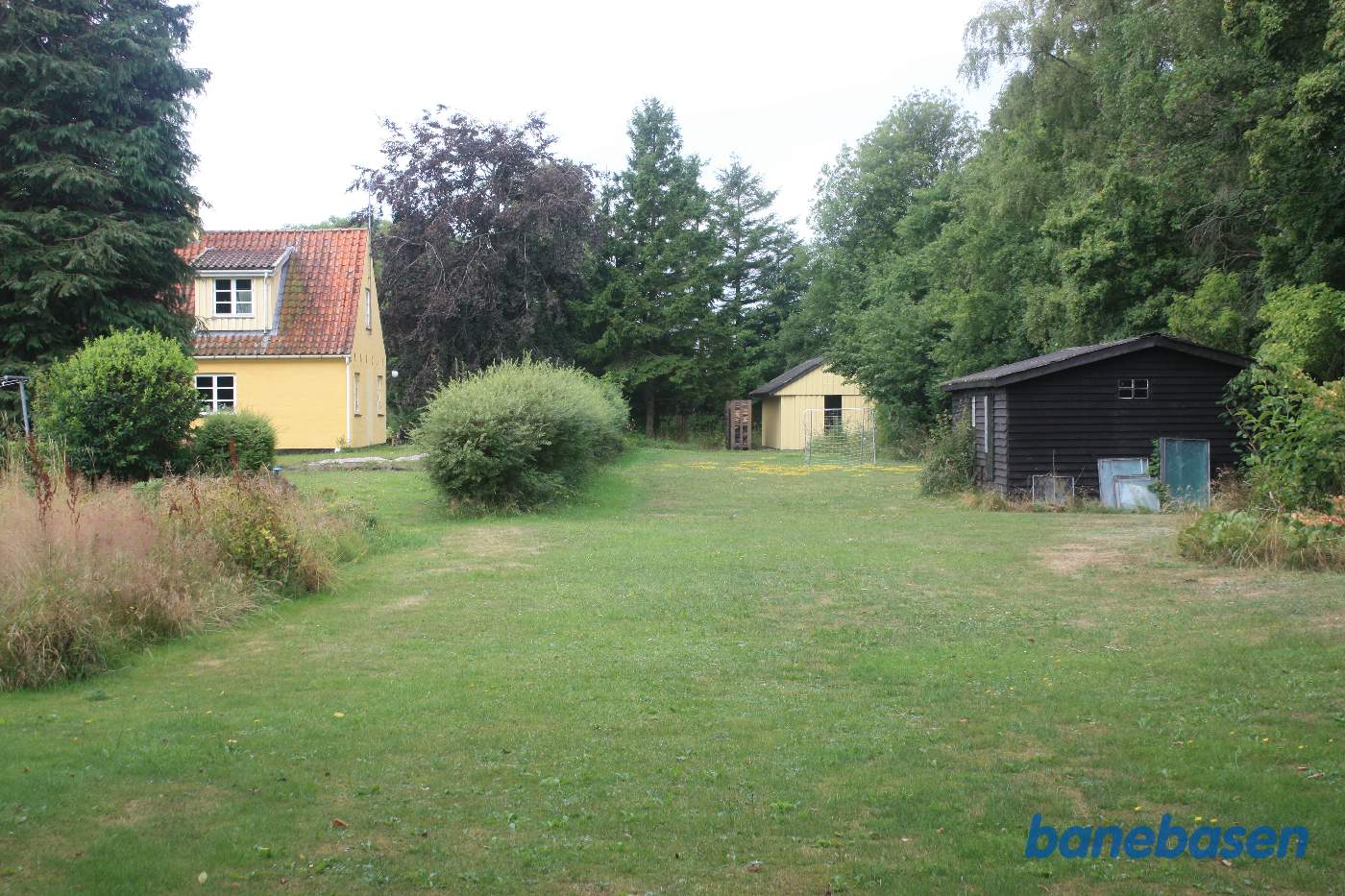 Vi står på banens tracé og kigger på perronen og sporet i retning mod Aakirkeby Vi står på banens tracé og kigger på perronen og sporet i retning mod Aakirkeby